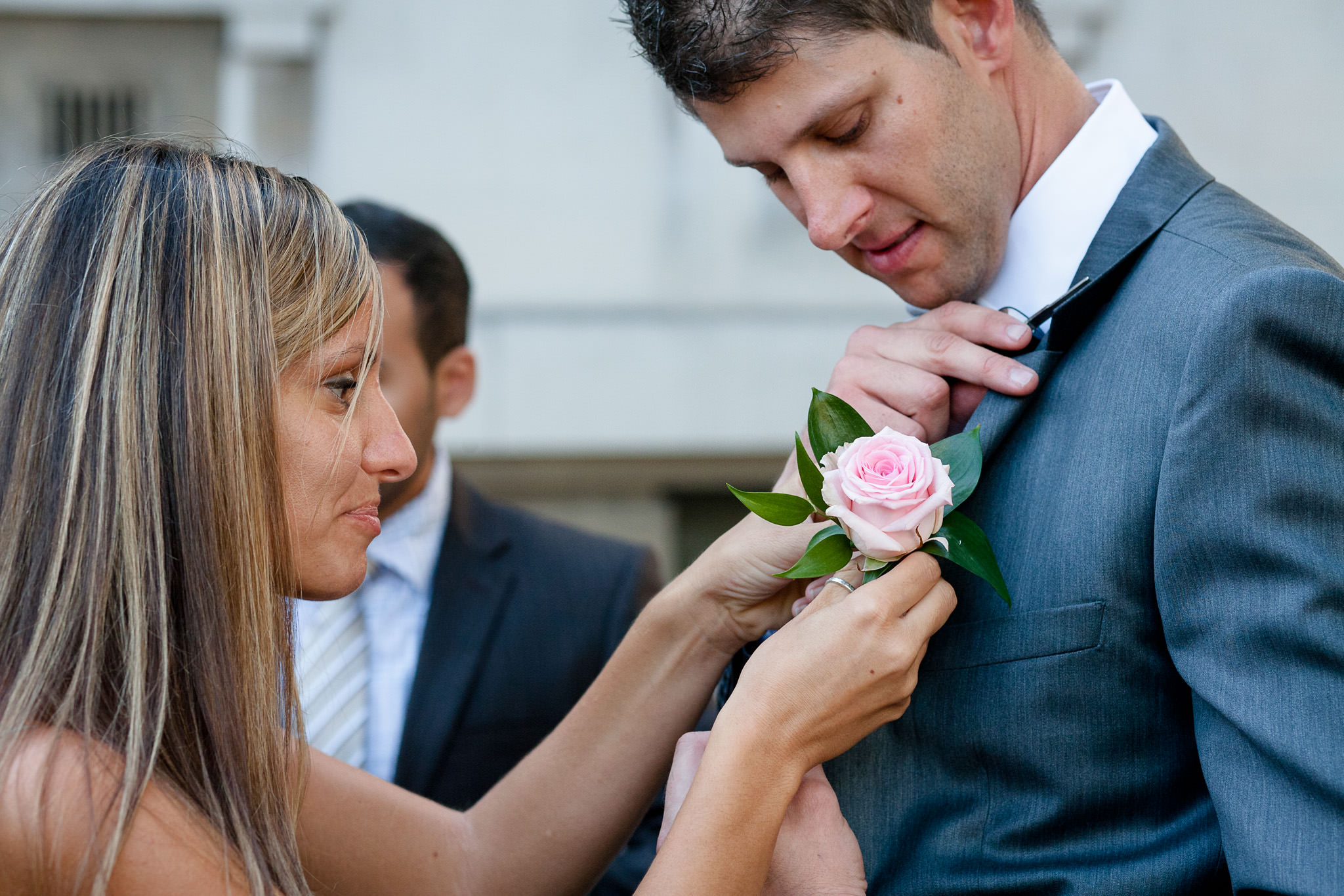 Old Marylebone Town Hall wedding groom is having his button flower pined in