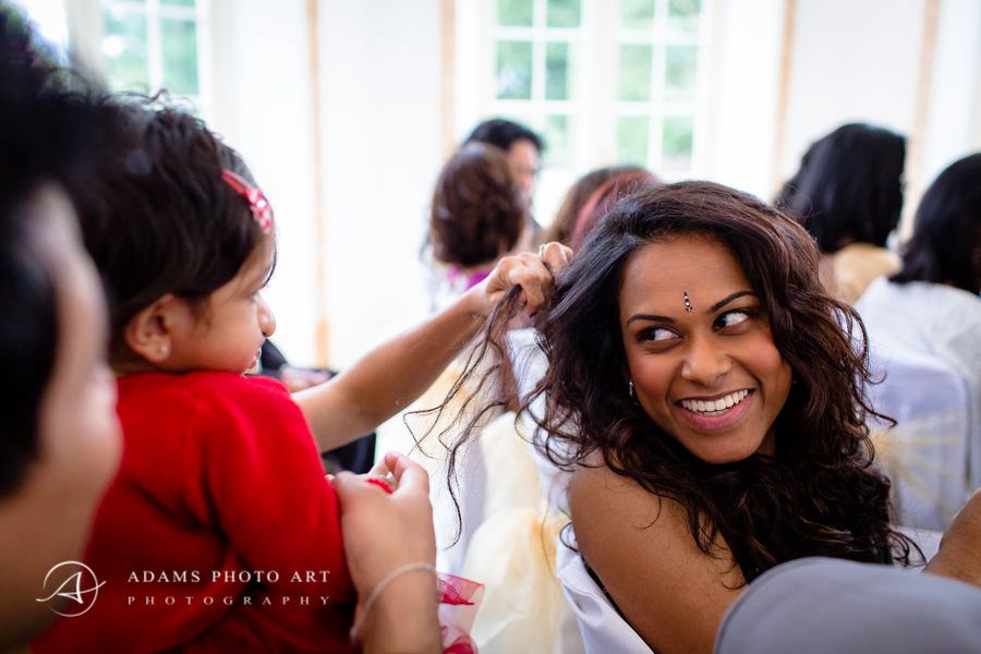 The girl is playing with the bride's hair
