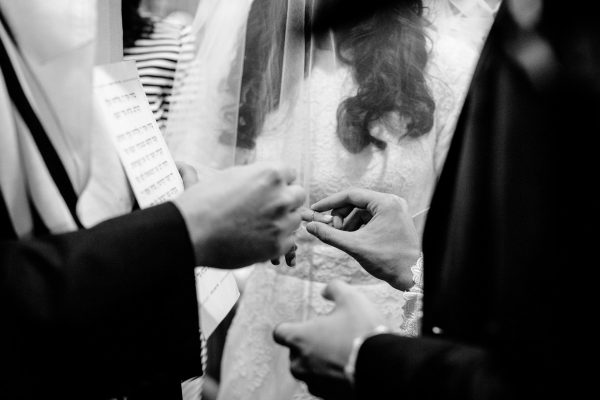 Jewish Wedding Photo groom puts a ring on the bride