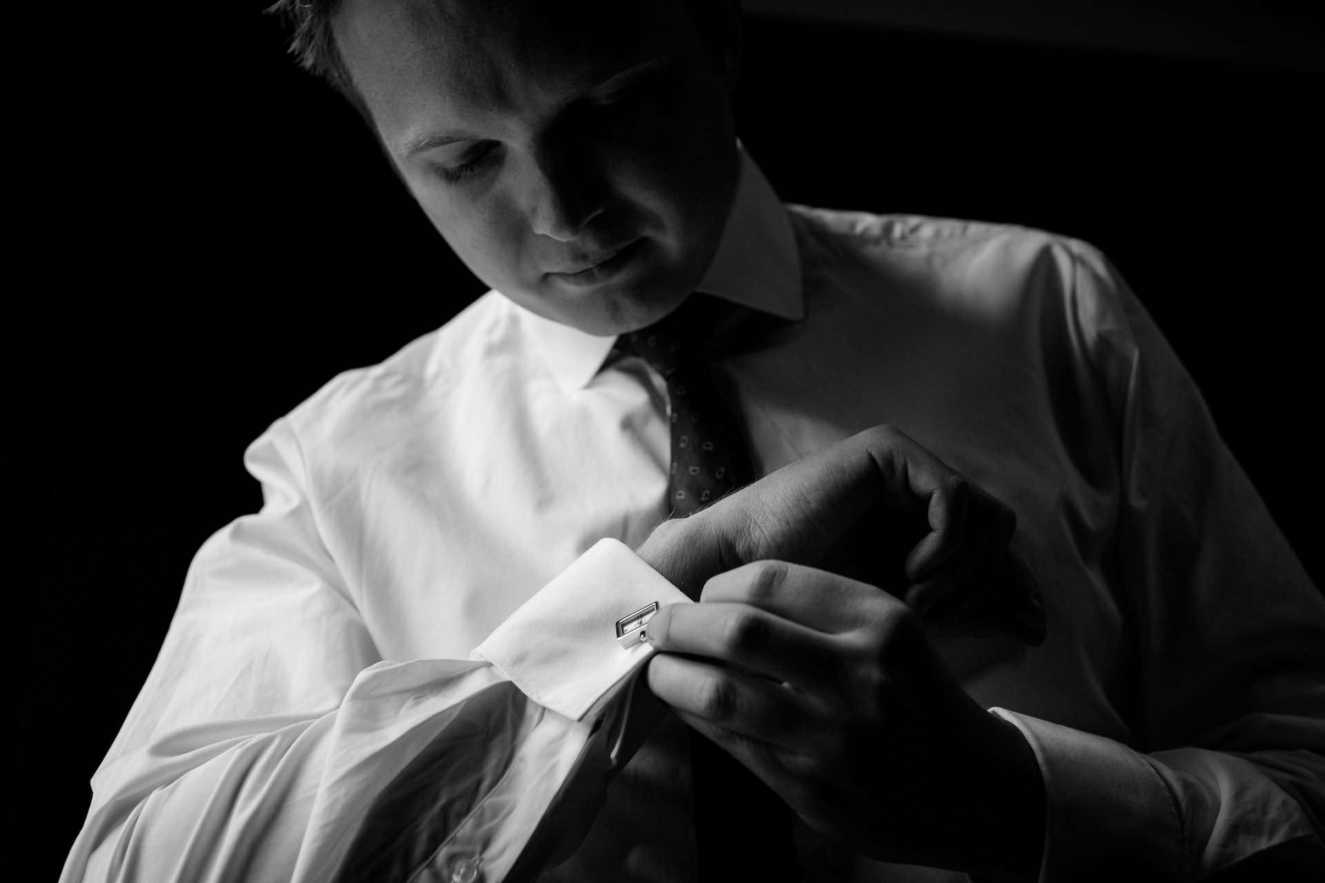 Wotton House wedding groom fixing his cufflinks
