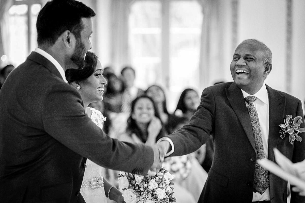 father of the bride shakes hand with groom art asian civil wedding