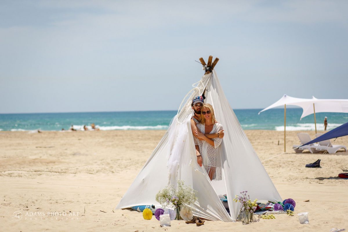 married couple are waking up in their wedding tent on the beach