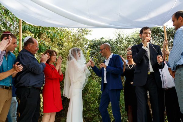 jewish wedding photographer groom put the ring on the bride