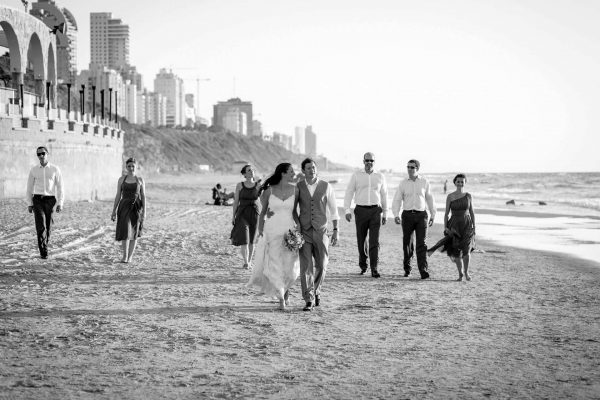 destination wedding photographer groom and the bridal party is walking by the sea