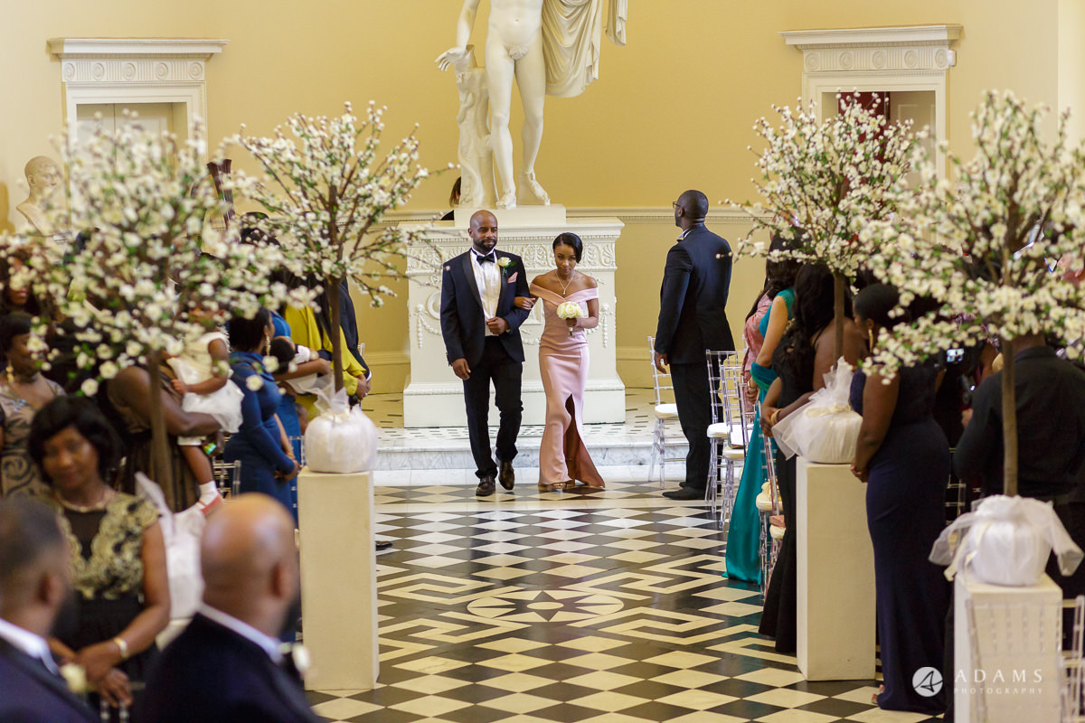 photographer syon park house wedding groomsman and bridesmaids walk down the aisle