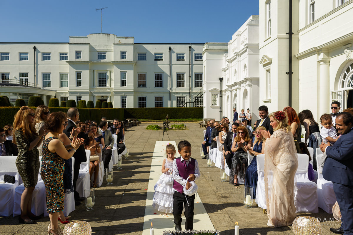 pinewood studios wedding page boy and a flower girl walking down the aisle