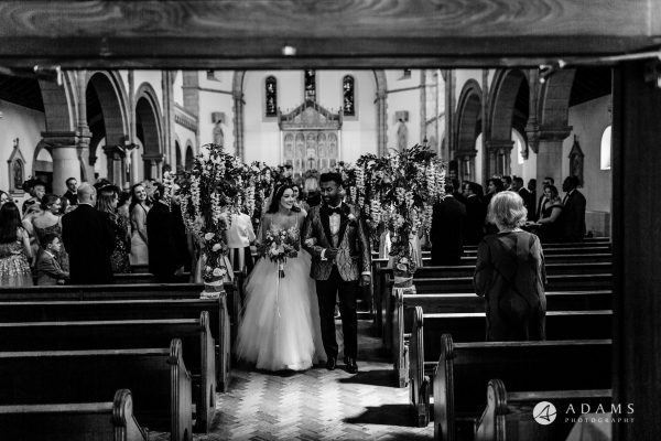 st donats castle wedding grooms and bride walk out of the church