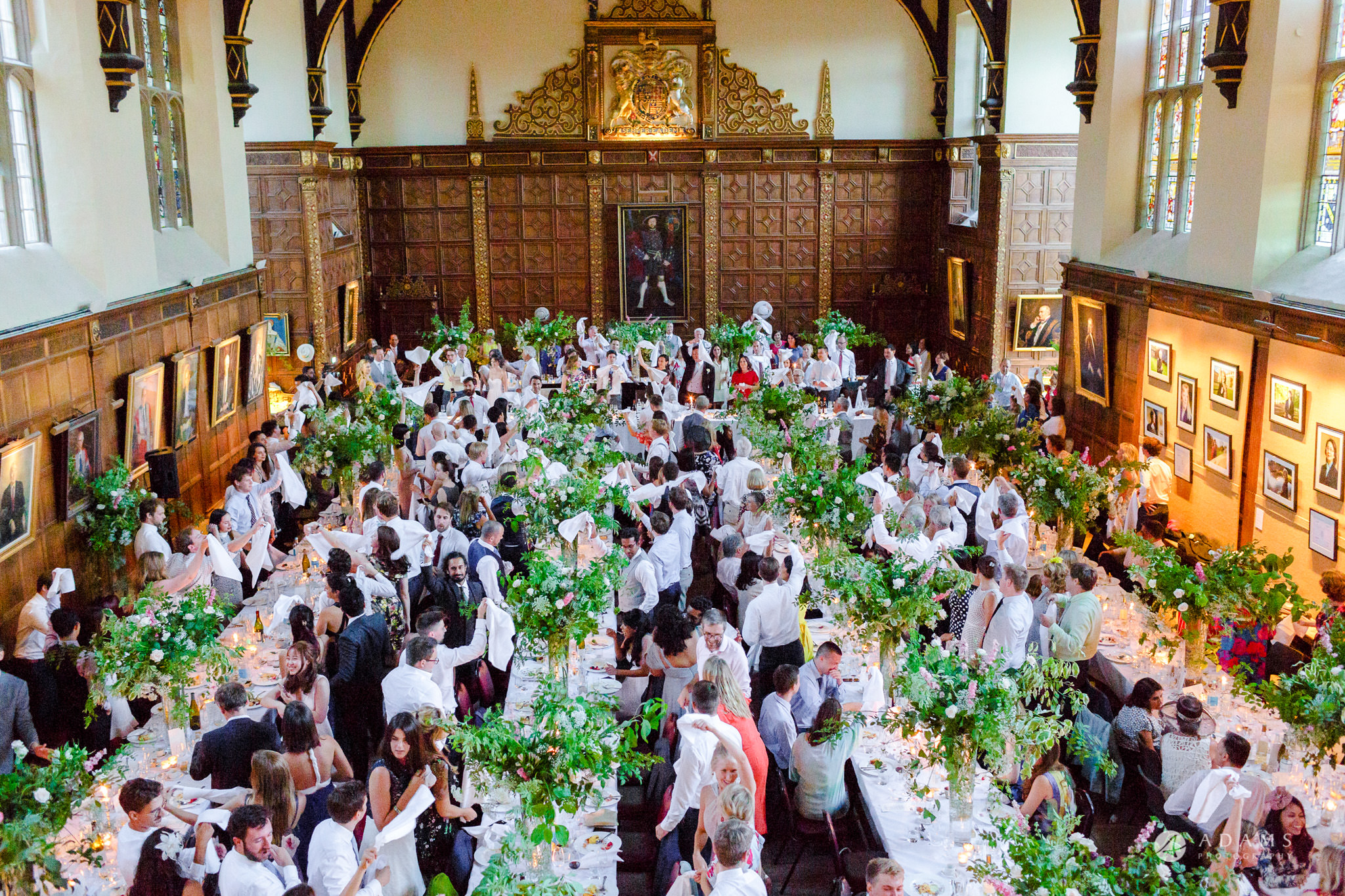 Trinity College Cambridge wedding everyone holds hands in the air
