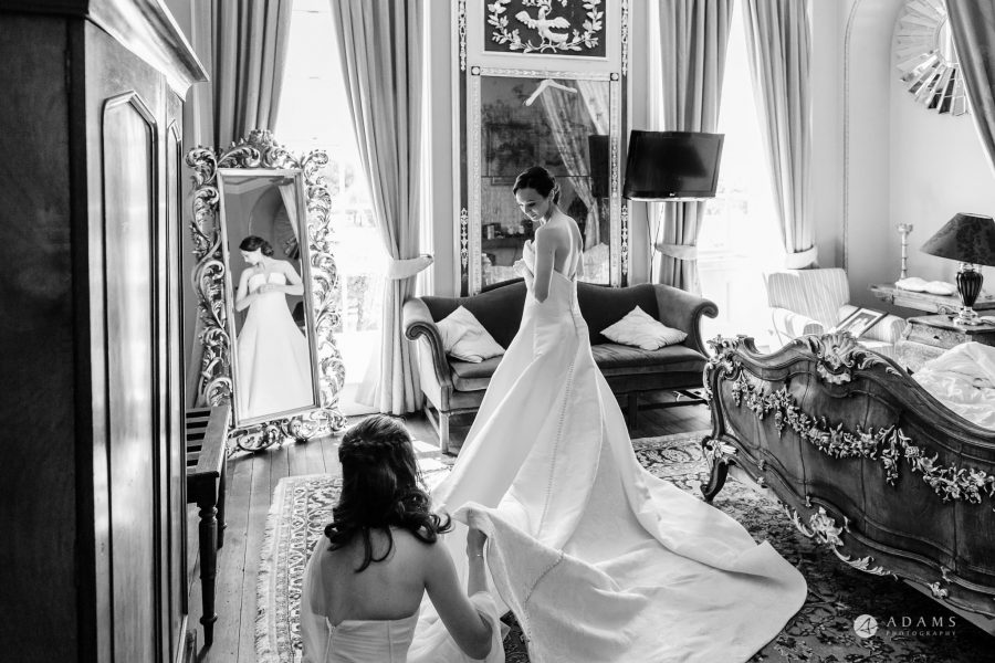 black and white wedding photography bride putting on her dress