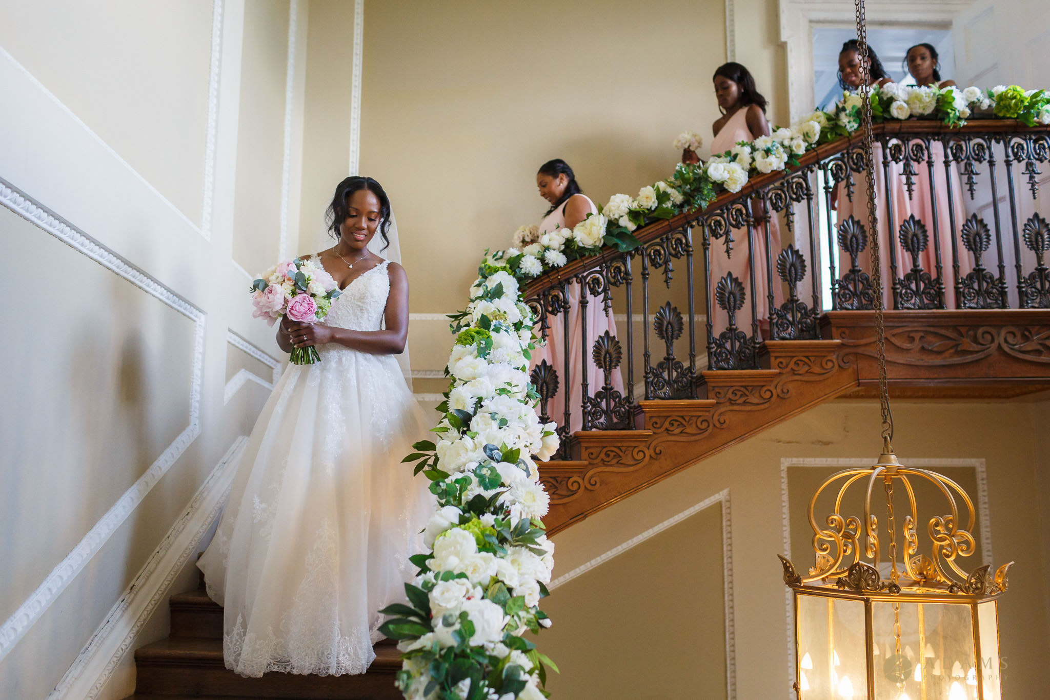 bride and bridesmaids walking down the stairs in Boreham House