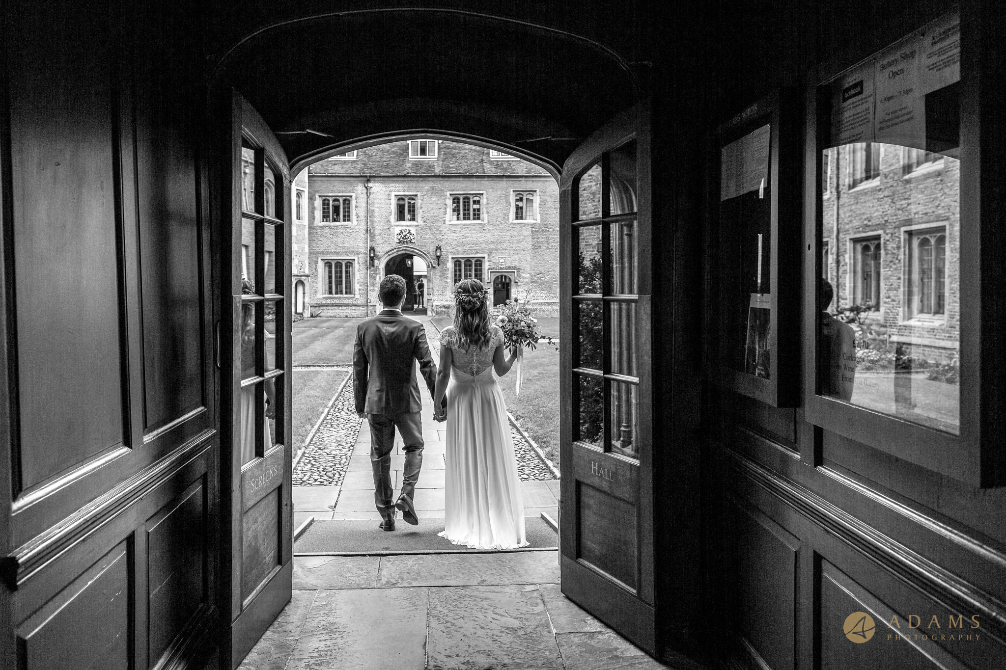 Cambridge Photographer bride and groom walk out through the doorway