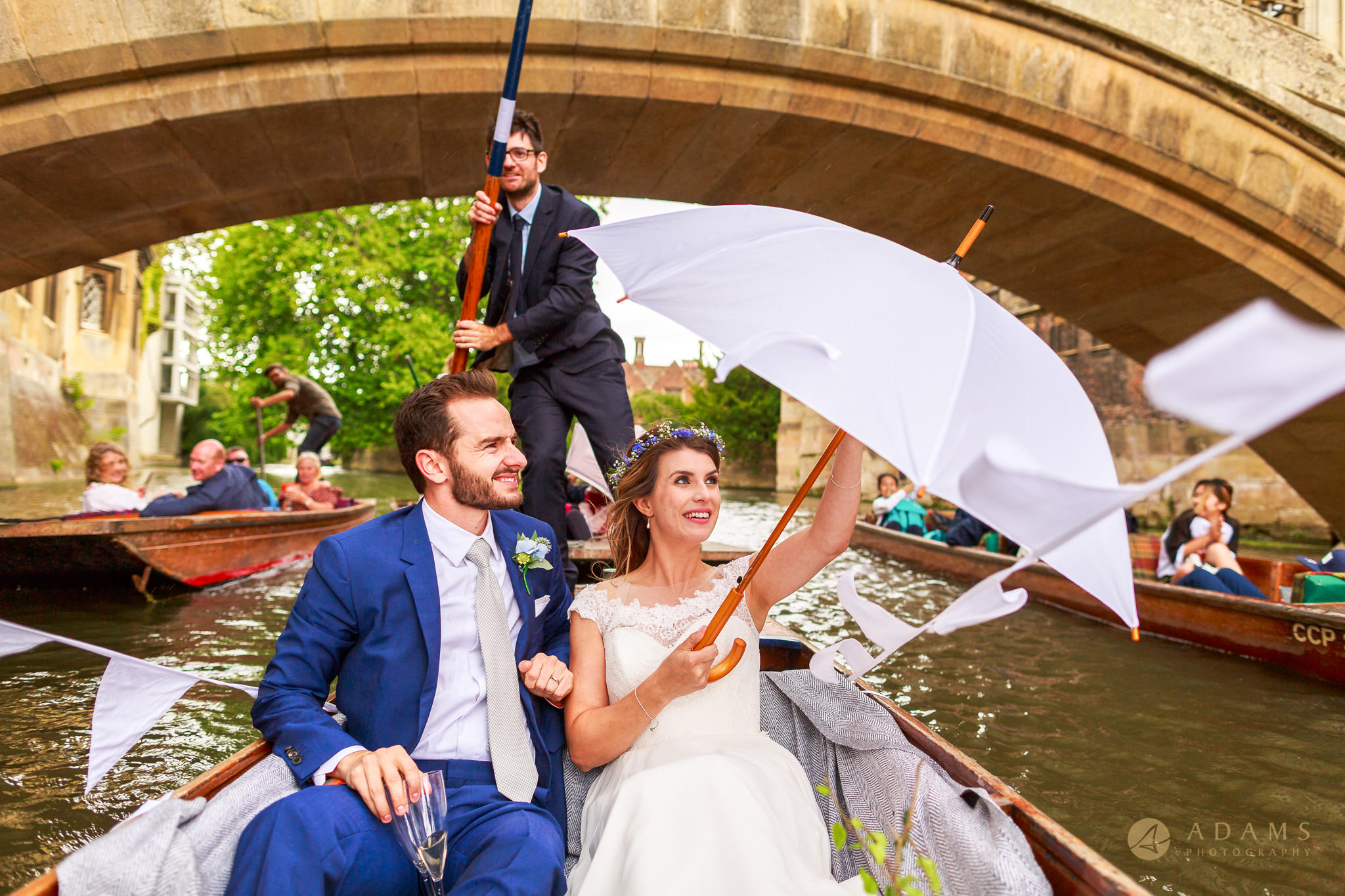 bride and groom holding umbrella while panting