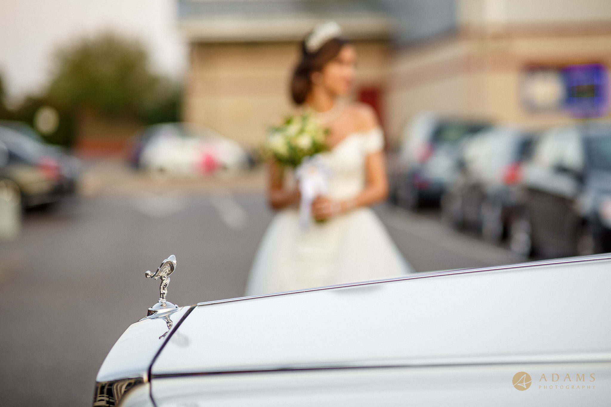 Bride by the wedding car