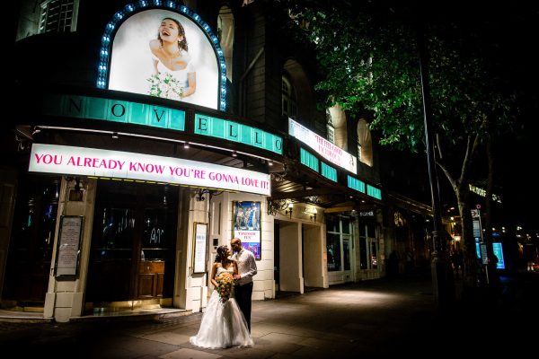 Couple posing in front of Waldorf Astoria Hotel in London after the wedding