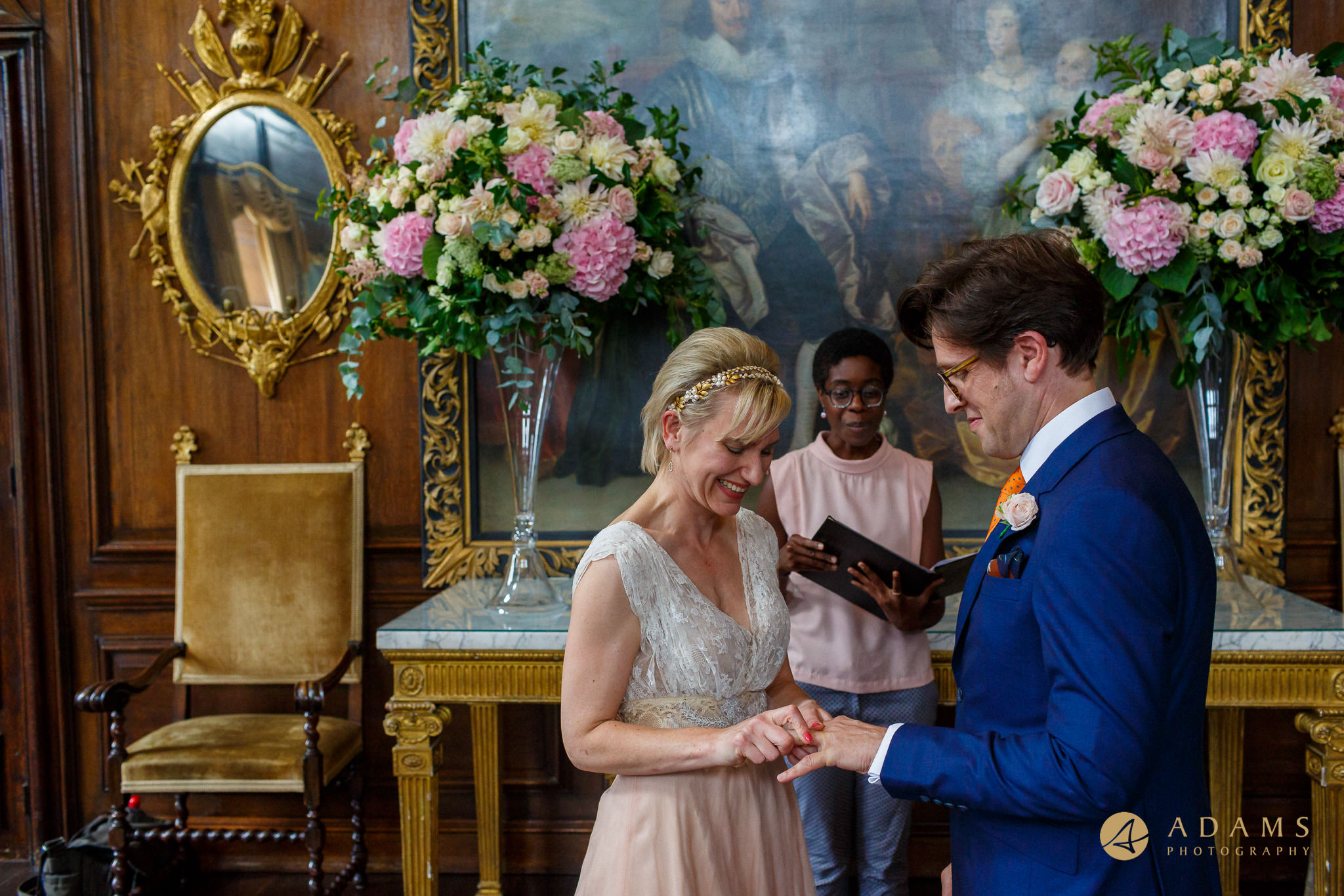 Bride putting a ring on groom at Royal Hospital in Chelsea