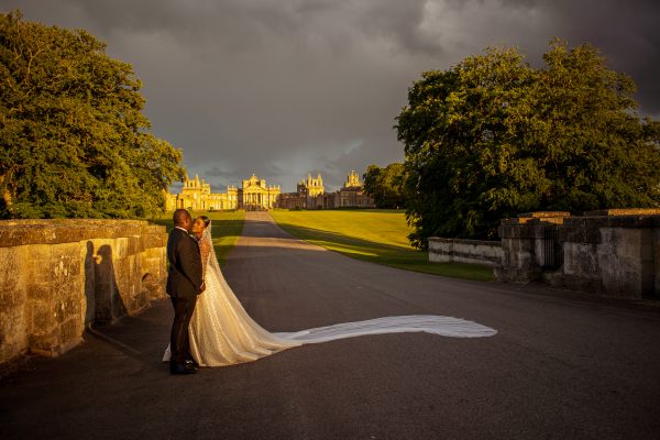 bride and groom posing in front of Blenheim Palace