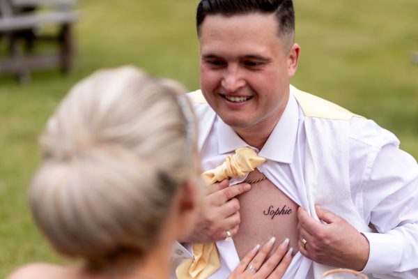 groom sowing the too on his chest
