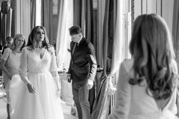 Bride wearing wedding dress and looking into the mirror at her Gosfield Hall wedding