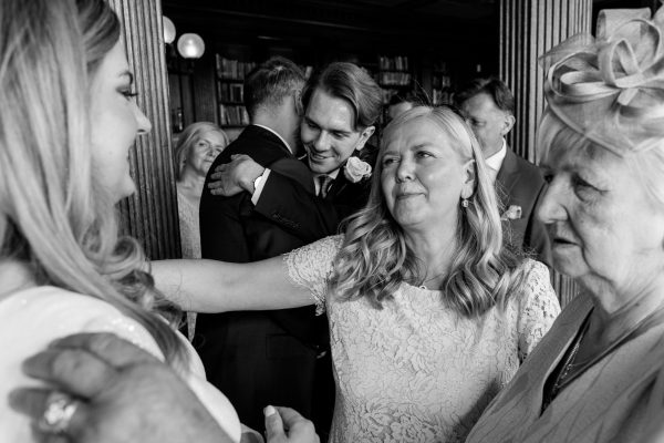 Blackened white photograph of mother of the bride about to hug the bride