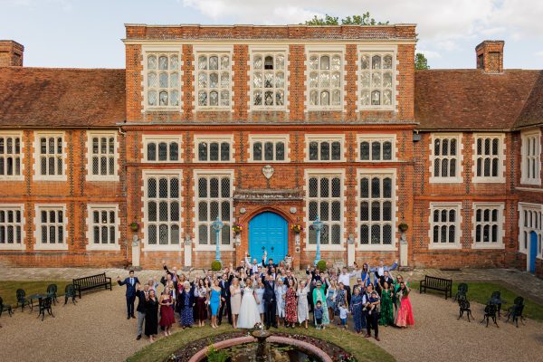 Group shot of the wedding guests int he courtyard of the Gosfield Hall