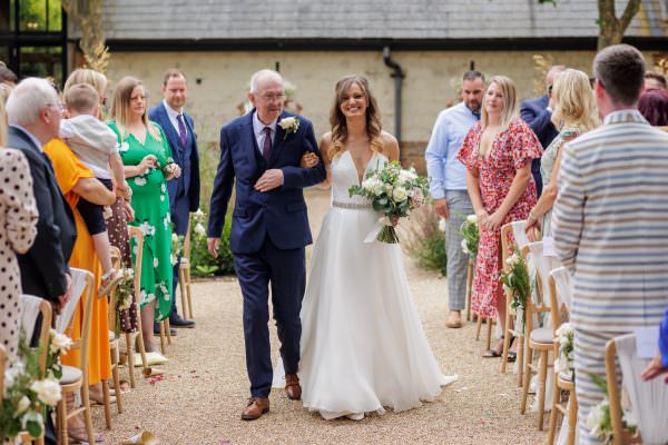 Bride walks with her father down the aisle