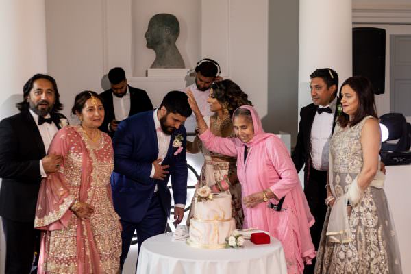 family feeing the couple with the cake