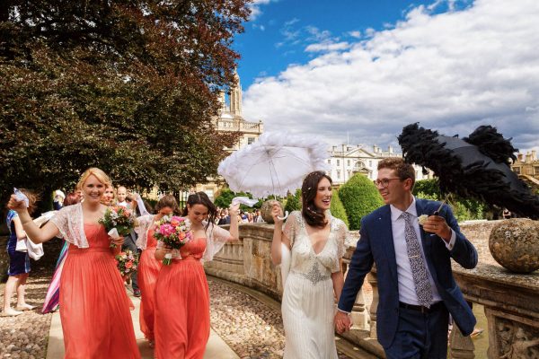 newly weds walking under umbrella at their wedding in Berkshire