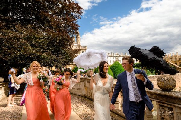 Cambridge Wedding Photographer married couple walking with umbrellas