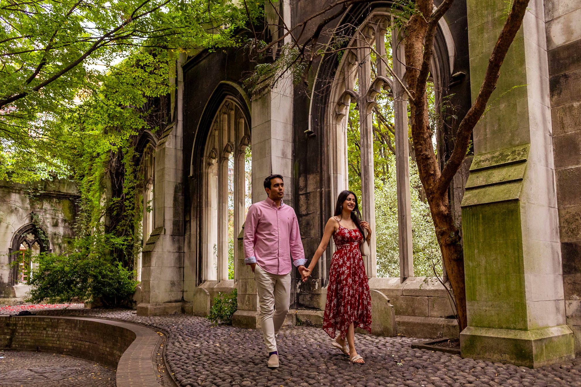 The couple is walking after the surprise proposal at St Dunstan in the East Church Garden