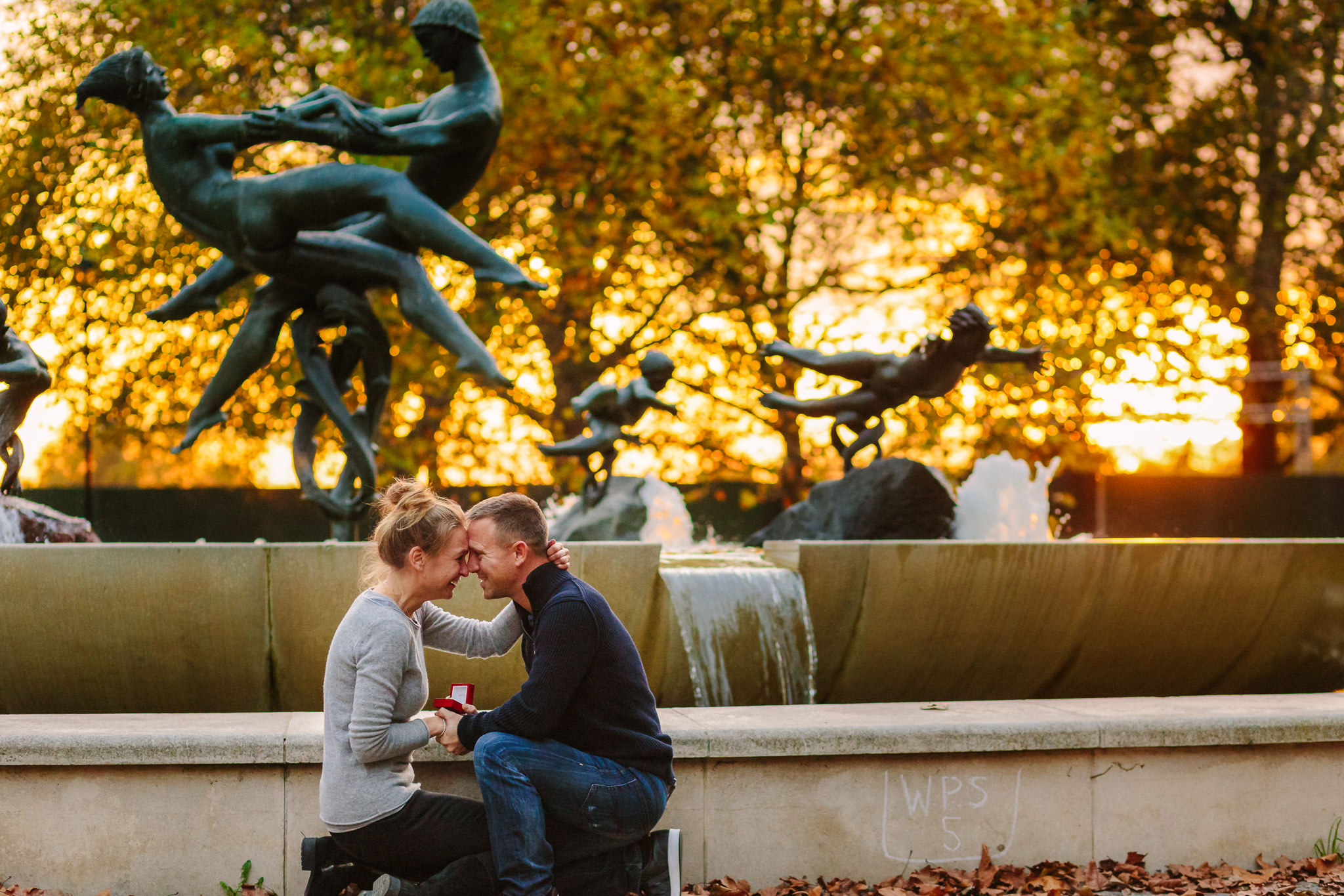 Couple enjoying the moment just after the engagement proposal in front of Joy of Life Fountain in Hyde Park
