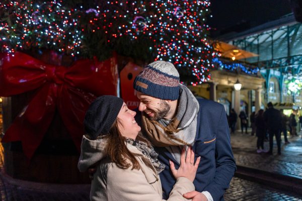 The couple hugging and smiling with joy after the proposal at Covent Garden in London
