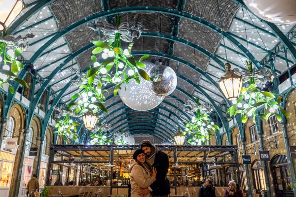 The couple hugging after the proposal at Covent Garden Apple Market in London
