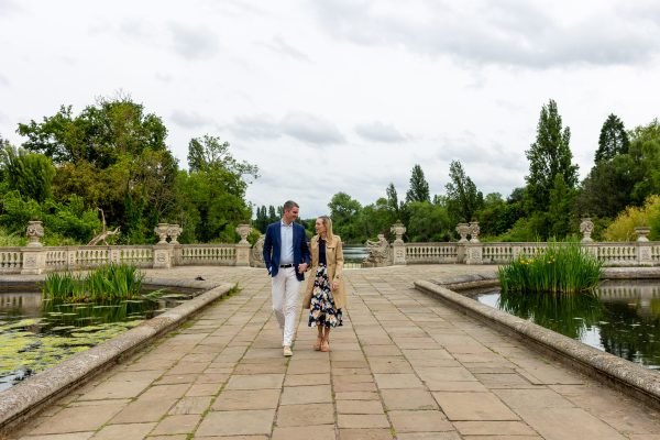 The couple walking holding hands after the proposal at Italian Gardens in London