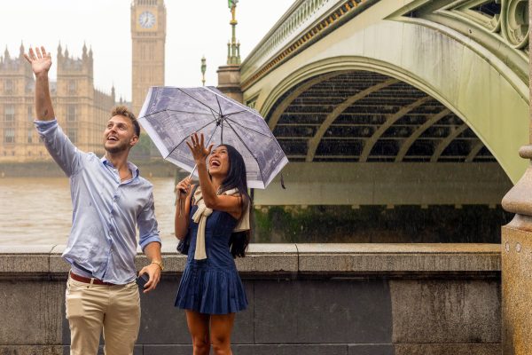 Happy couple saying hello to their friends after a proposal by the Arch in front of Big Ben