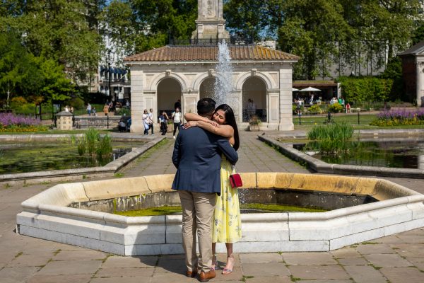 Couple hugging each other after the proposal at Italian Gardens in front of the fauntain